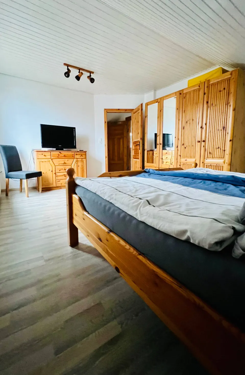 Schlafzimmer 1 mit Fernseher und Kiefernmöbeln