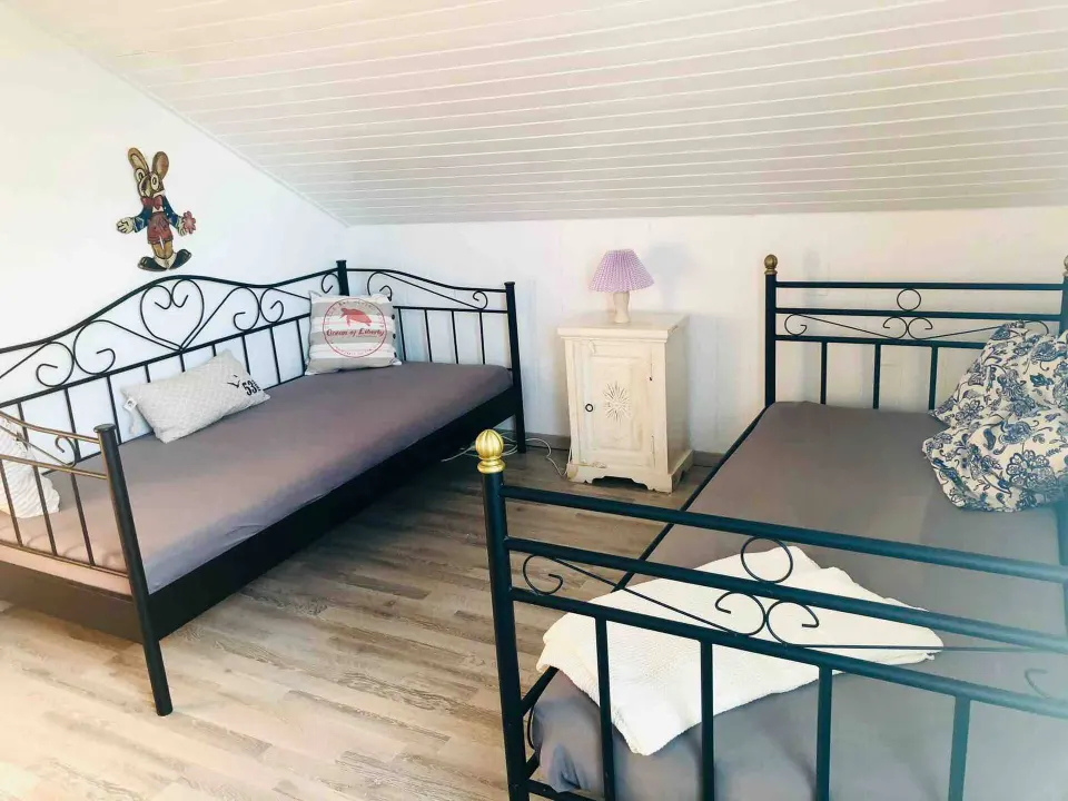 Zwei Einzelbetten mit schwarzen Metallgestellen im zweiten Schlafzimmer
