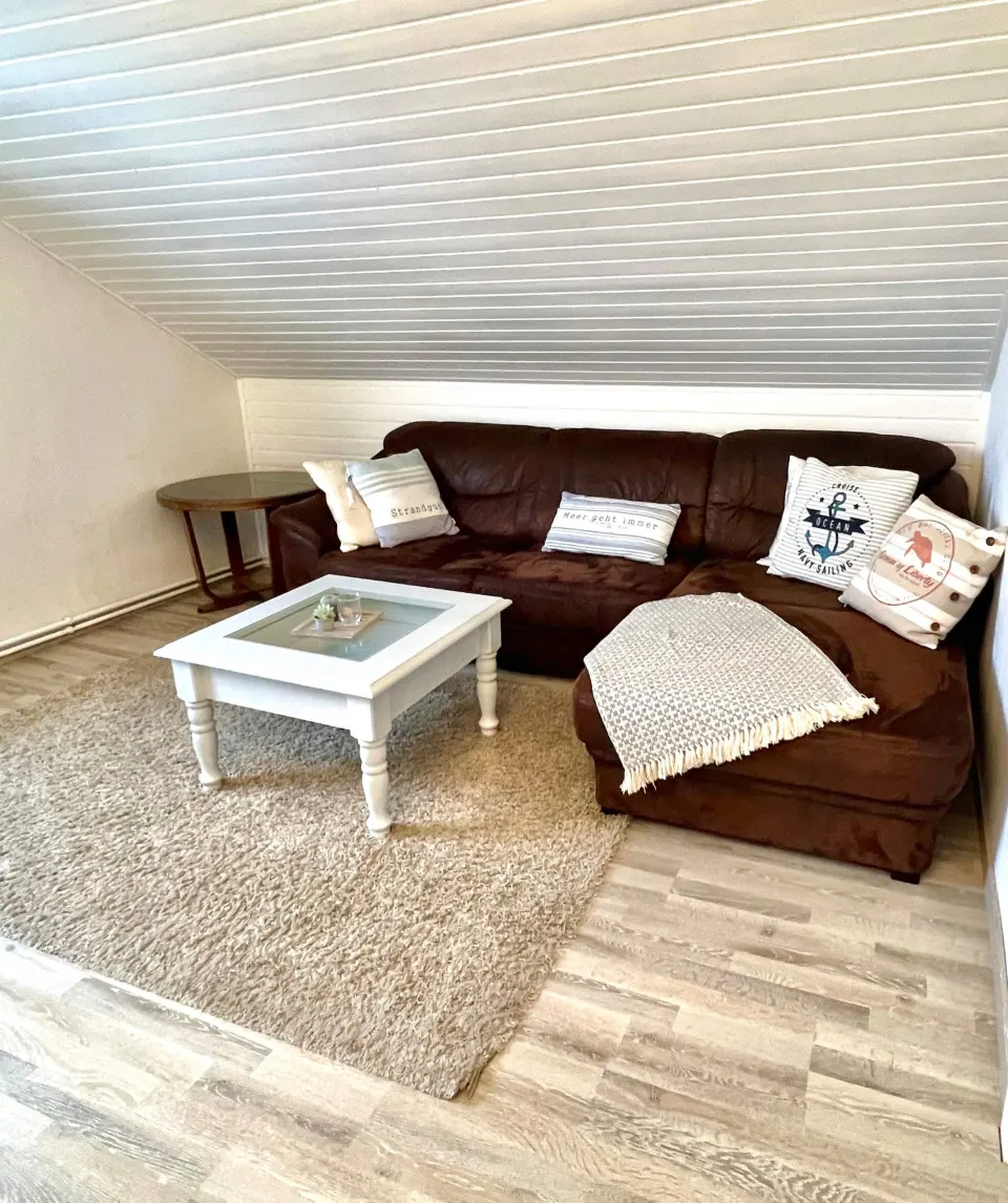 Ledercouch mit maritimen Kissen und Couchtisch im Wohnzimmer